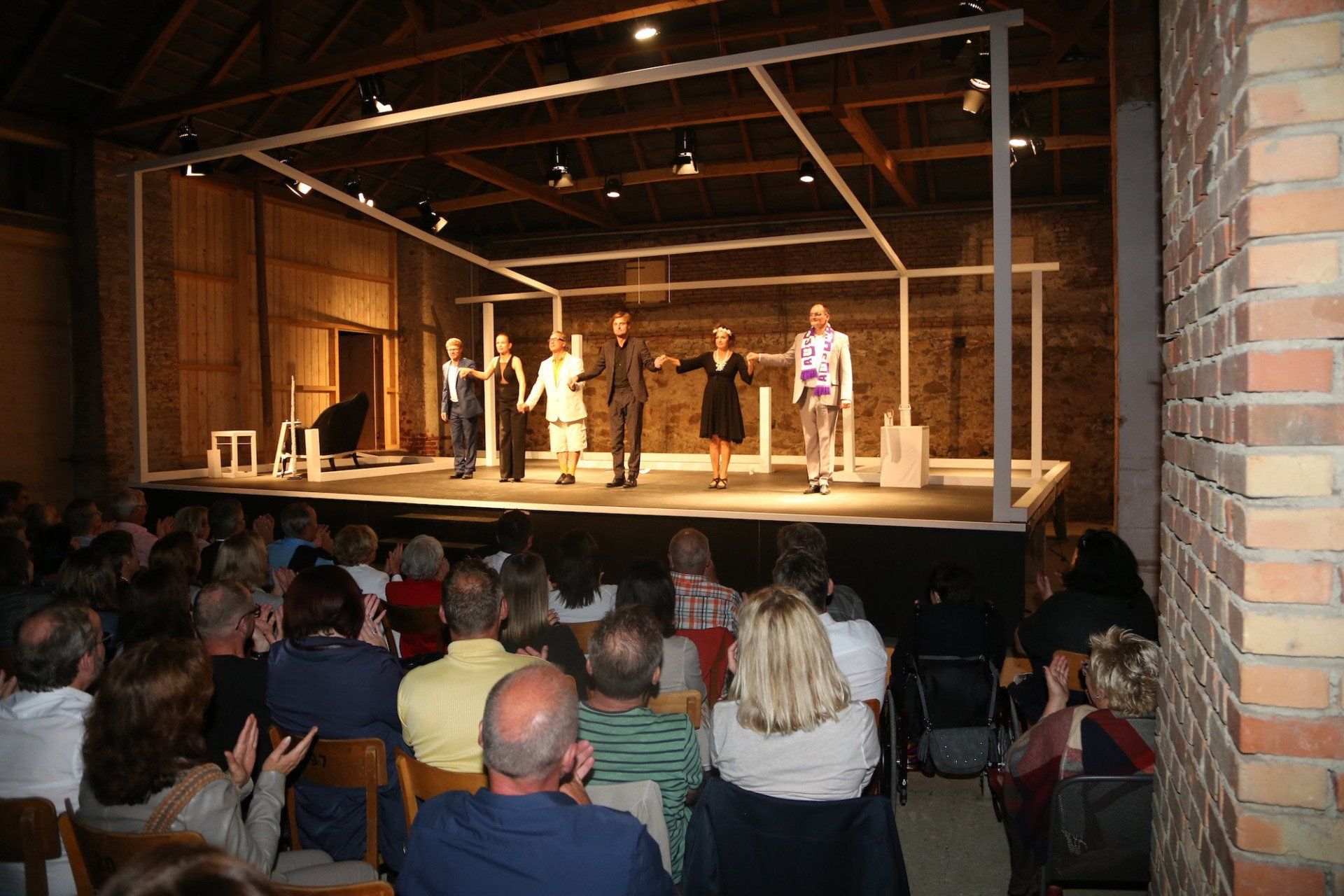 Eine Gruppe von Menschen, die vor einer Menschenmenge auf einer Bühne stehen