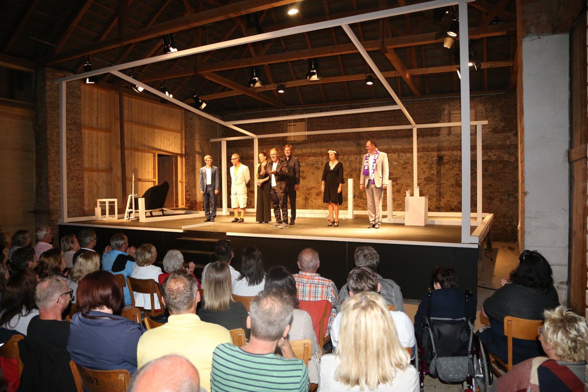 Eine Gruppe von Menschen, die vor einer Menschenmenge auf einer Bühne stehen