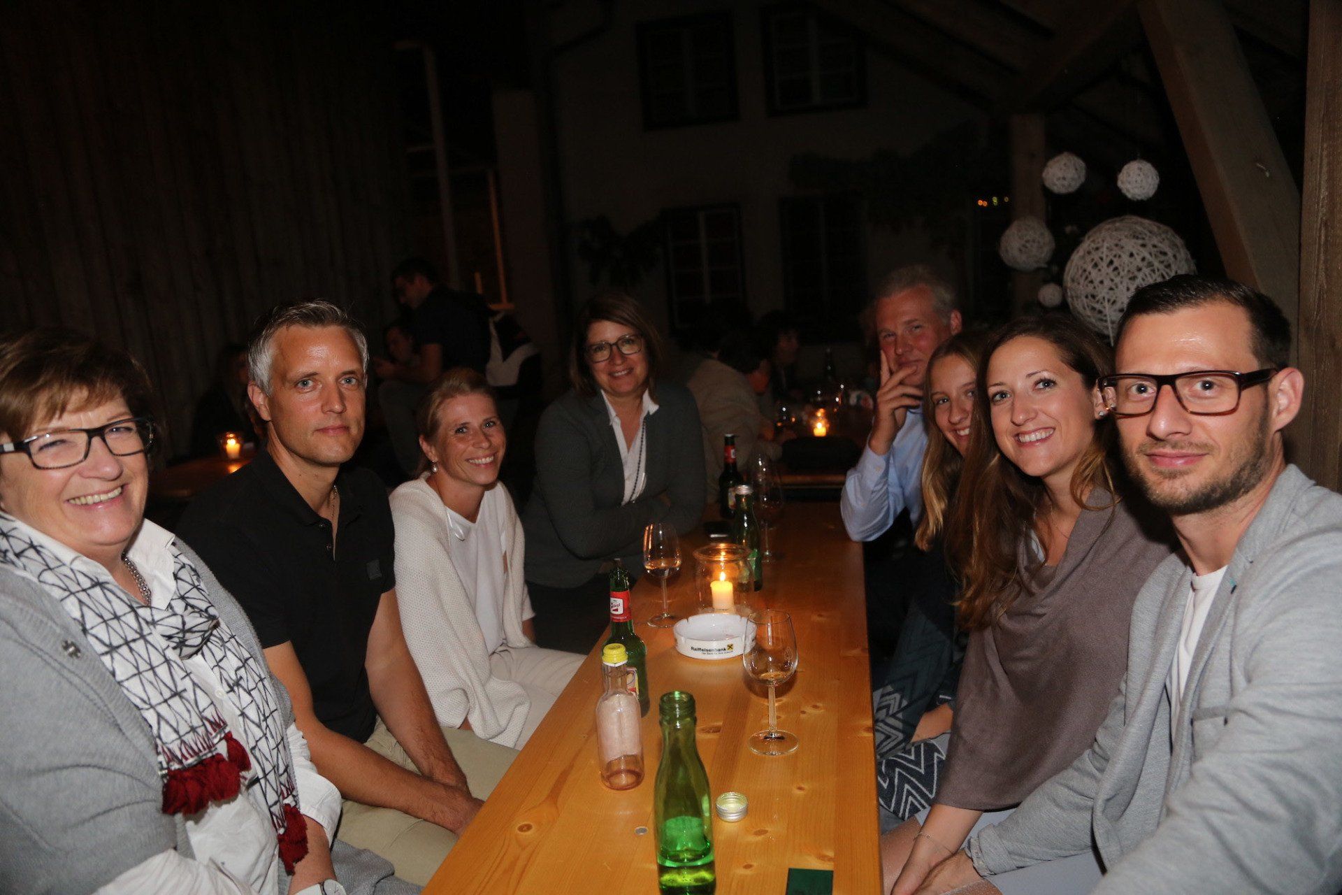 Eine Gruppe von Menschen sitzt an einem langen Holztisch.