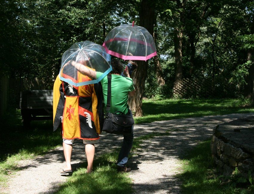 Ein Mann und eine Frau gehen mit Regenschirmen einen Weg entlang