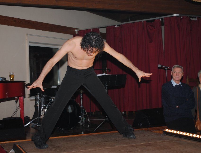 Ein Mann ohne Hemd tanzt auf einer Bühne