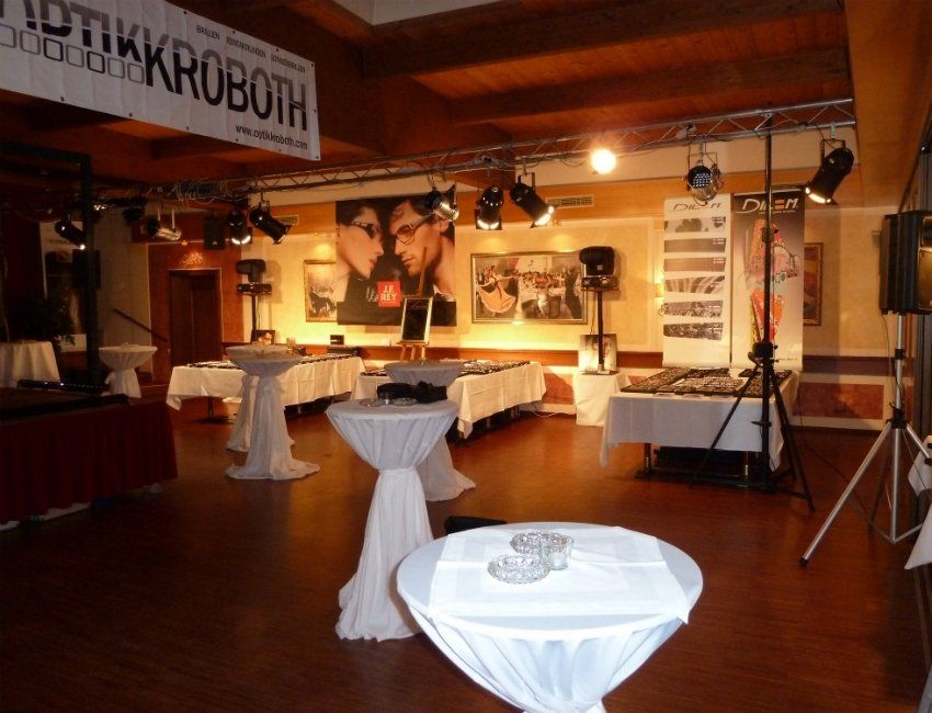 Ein Raum mit Tischen und einem Schild mit der Aufschrift „Optikroboth“