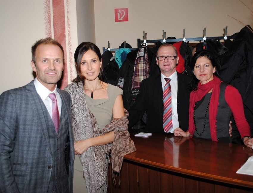 Eine Gruppe von Menschen steht vor einem roten Schild mit der Aufschrift d