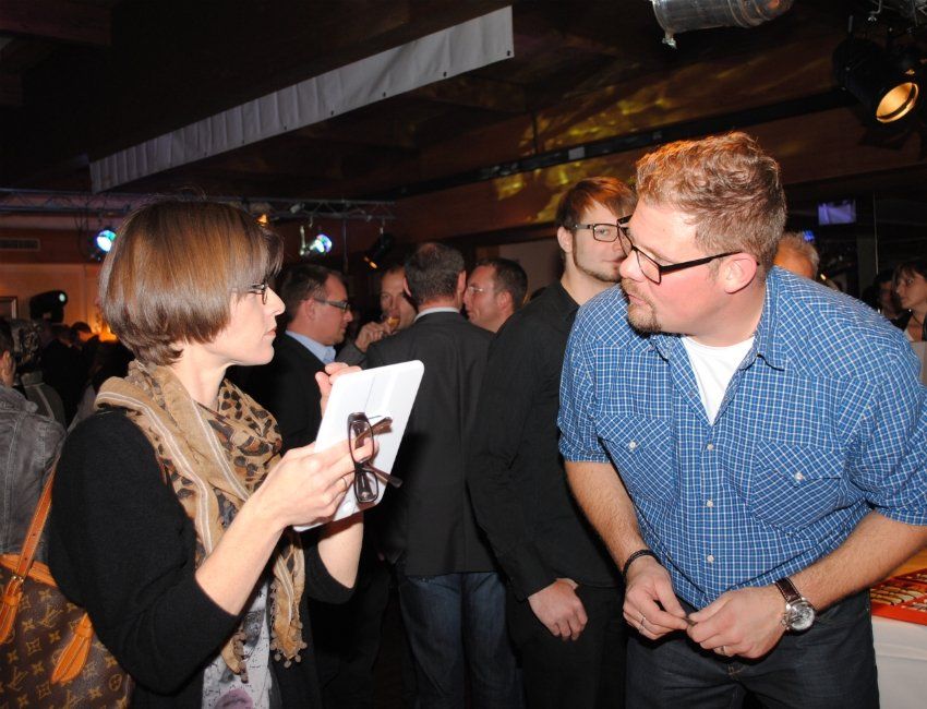 Eine Frau spricht mit einem Mann in einem überfüllten Raum