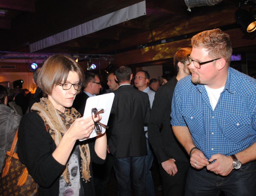 Ein Mann und eine Frau unterhalten sich in einem überfüllten Raum