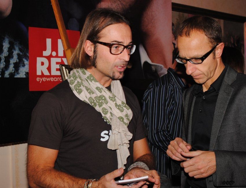 Zwei Männer stehen vor einem Schild mit der Aufschrift „Ji Re“