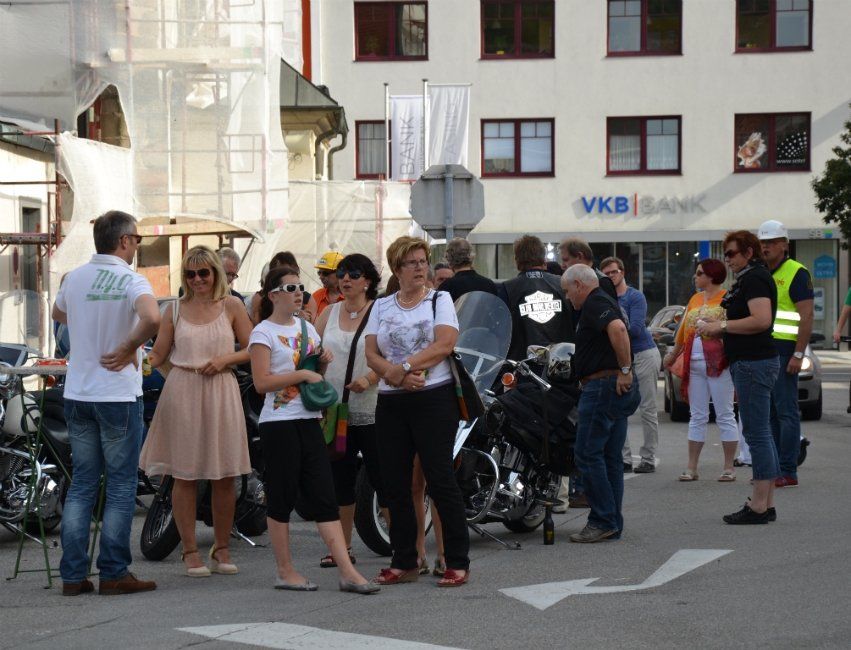 Eine Gruppe von Menschen steht vor einem Gebäude mit der Aufschrift „VKB Bank“.