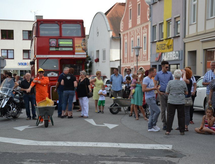 Eine Gruppe von Menschen versammelt sich vor einem roten Doppeldeckerbus