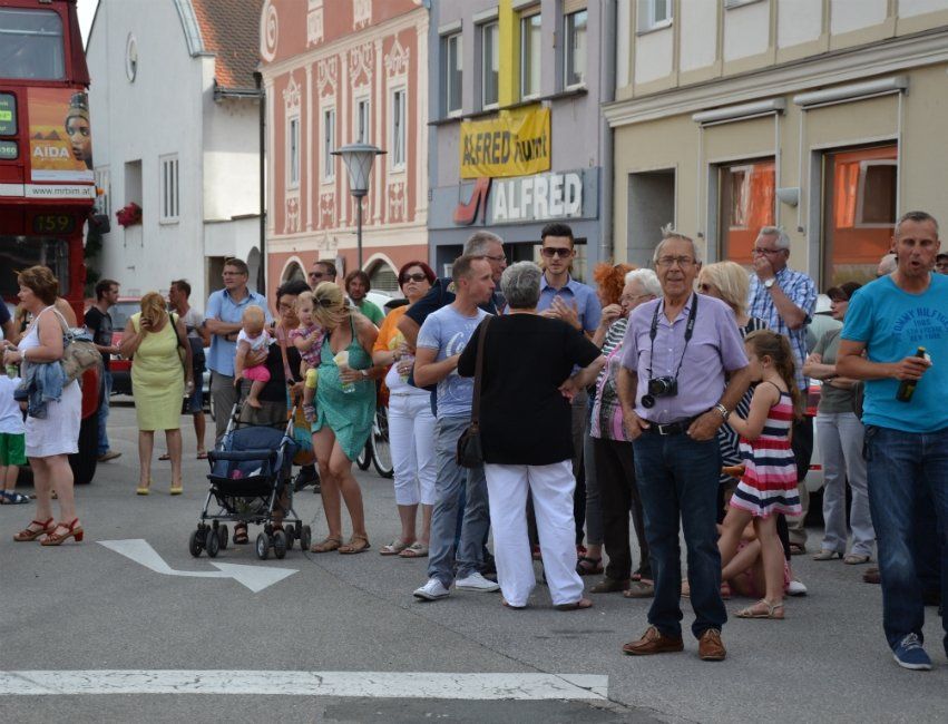 Eine Gruppe von Menschen steht vor einem Geschäft namens Alfred