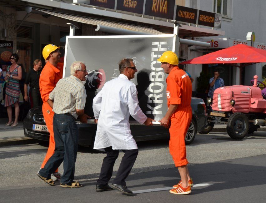 Eine Gruppe Männer schiebt eine Kiste mit der Aufschrift „Kroboth“