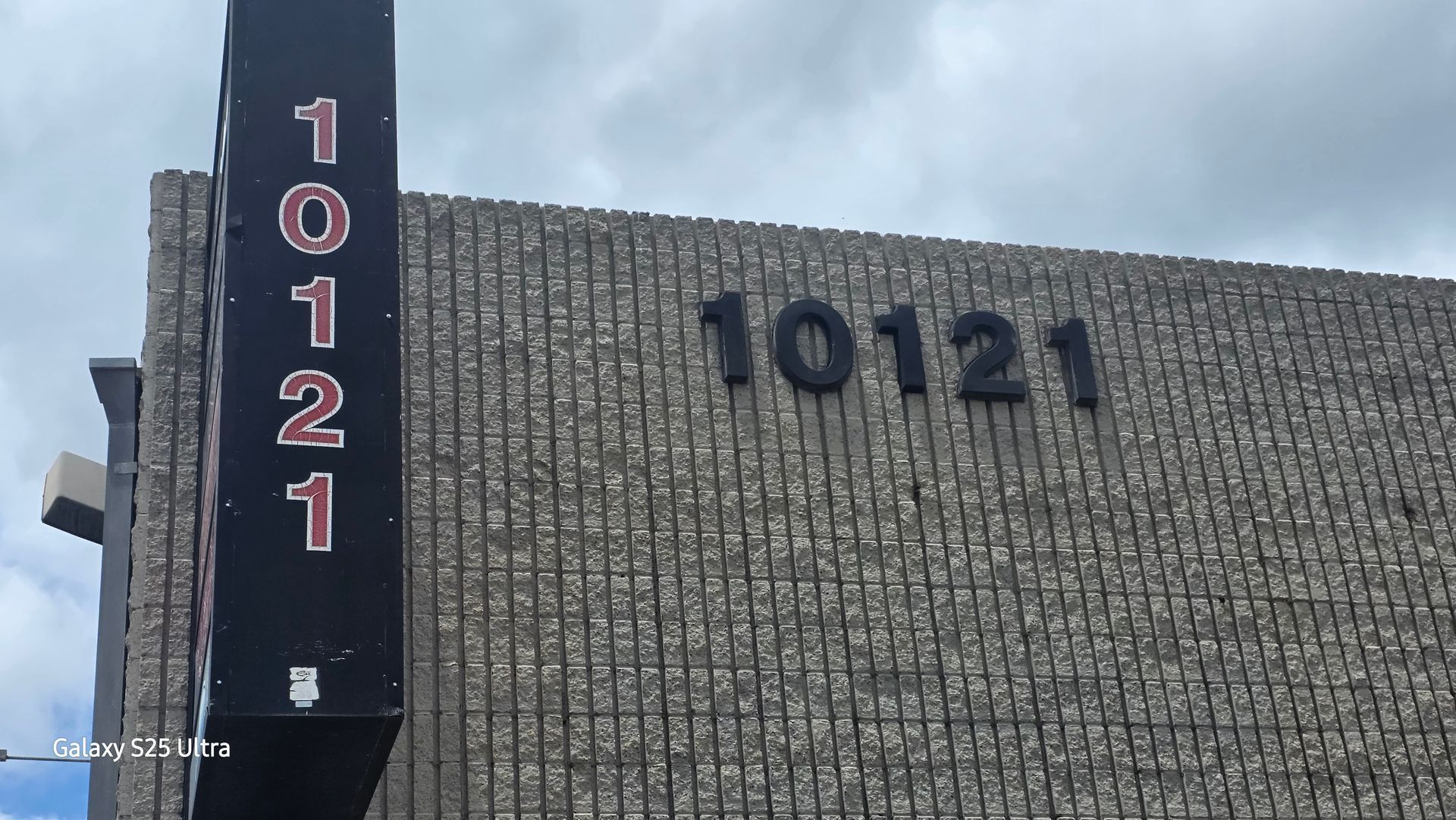 Building exterior with the number 10121 displayed in black and red on the wall