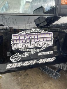 A black car with a sticker on the side that says dayton wrecker service