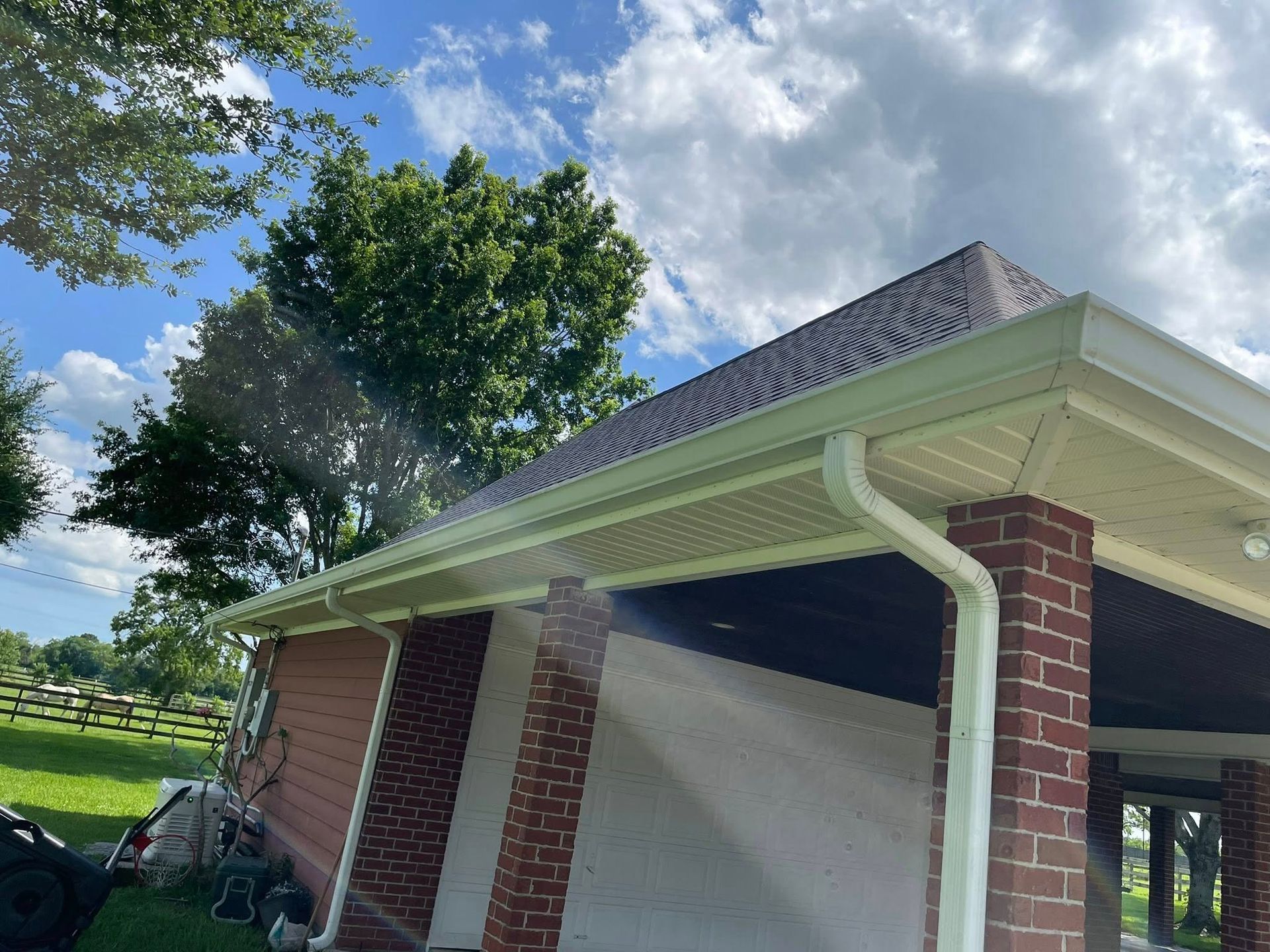 A house with a porch and a gutter on the roof.
