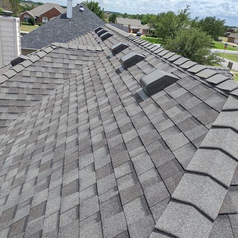 A roof with a lot of shingles and a chimney on it.