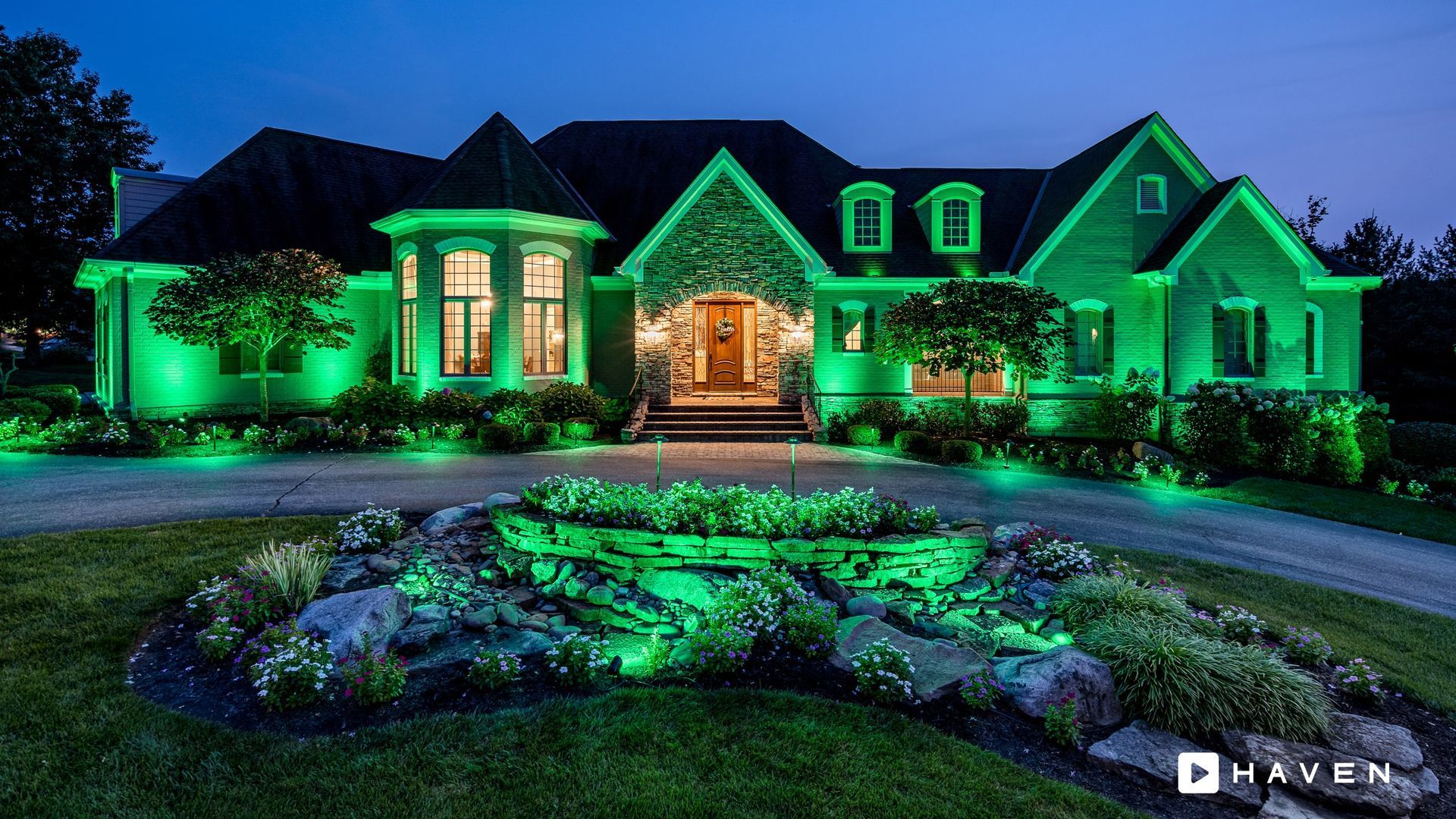 A large house is lit up with green lights at night.