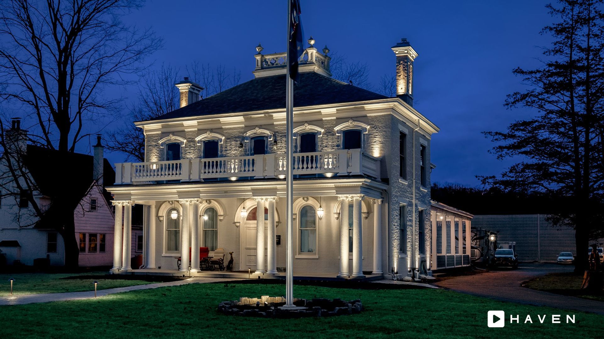 A large white house is lit up at night