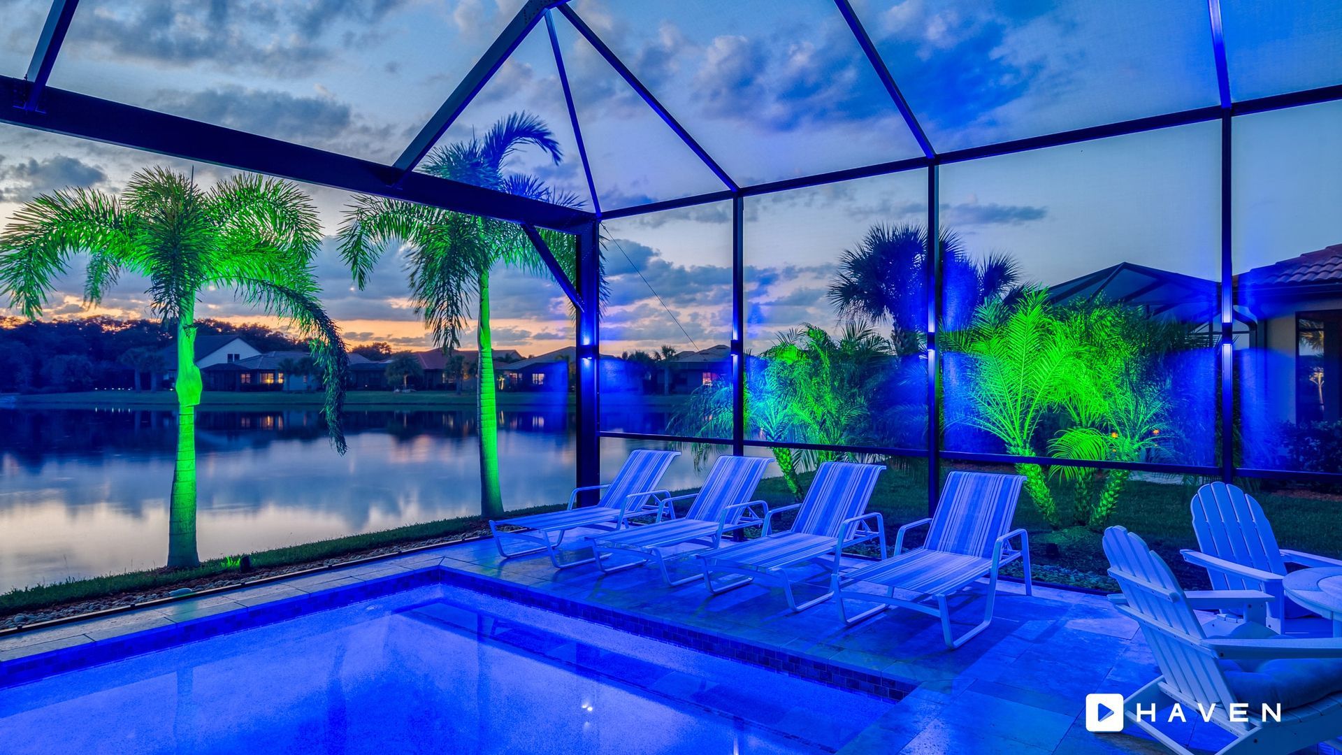 A swimming pool is lit up with blue lights at night.