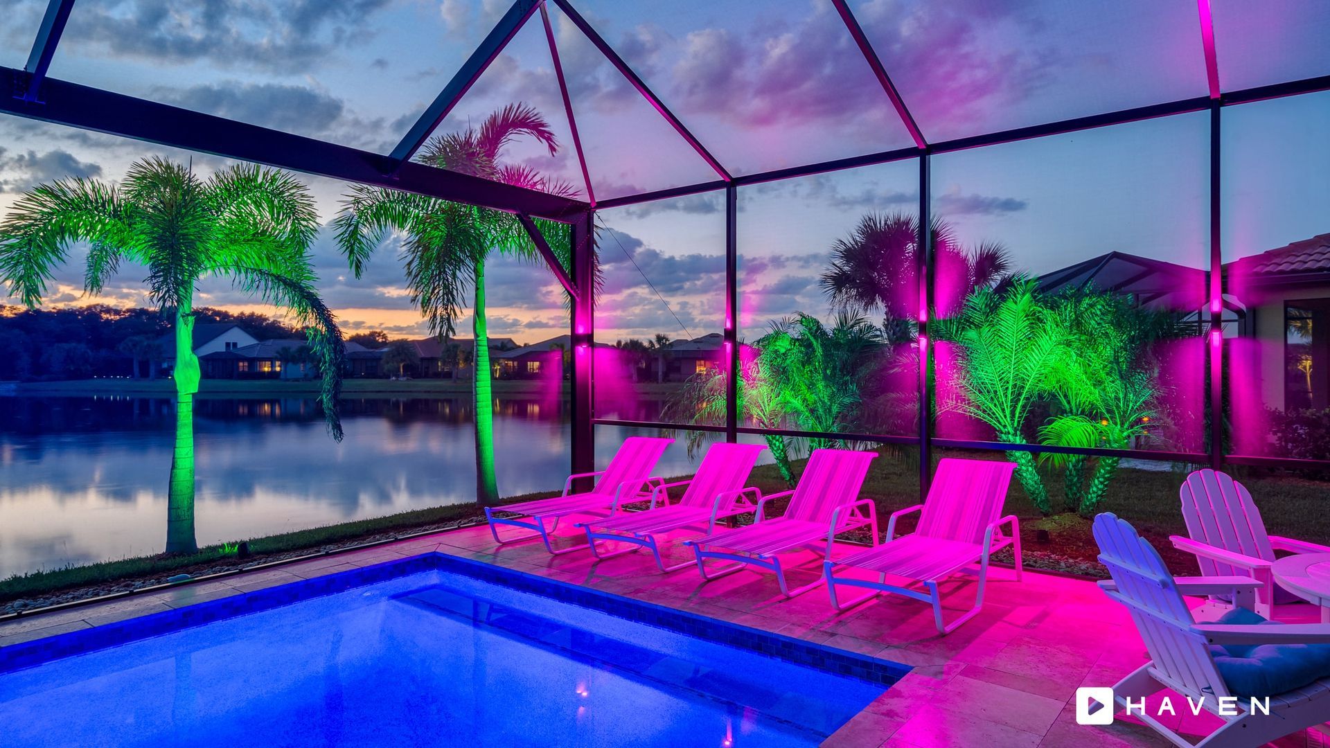 A swimming pool is lit up with purple and green lights.