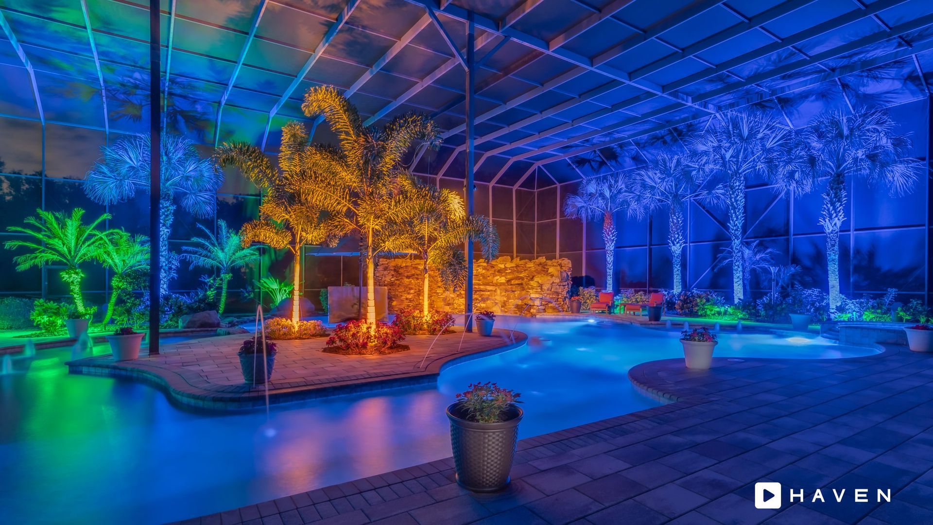 A large swimming pool is lit up at night with christmas lights.