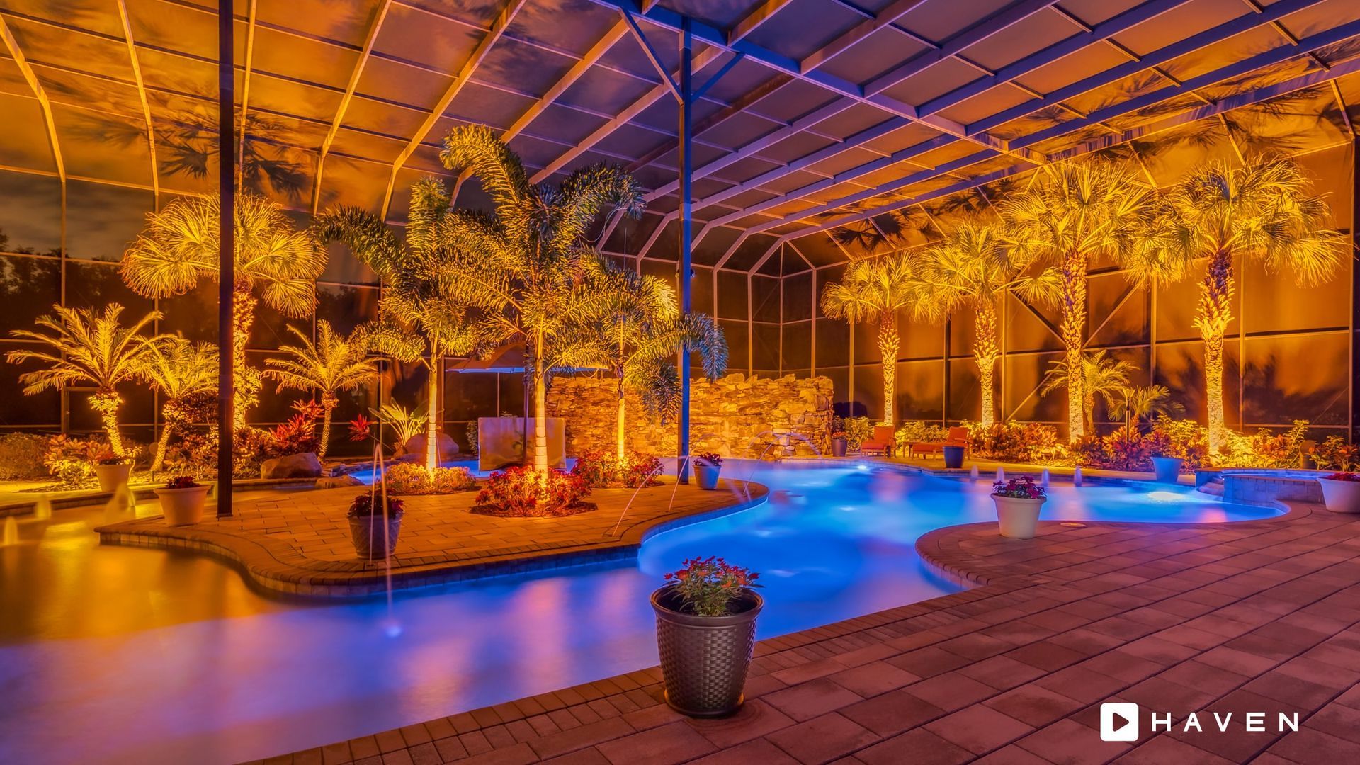 A large swimming pool is lit up at night with christmas lights.