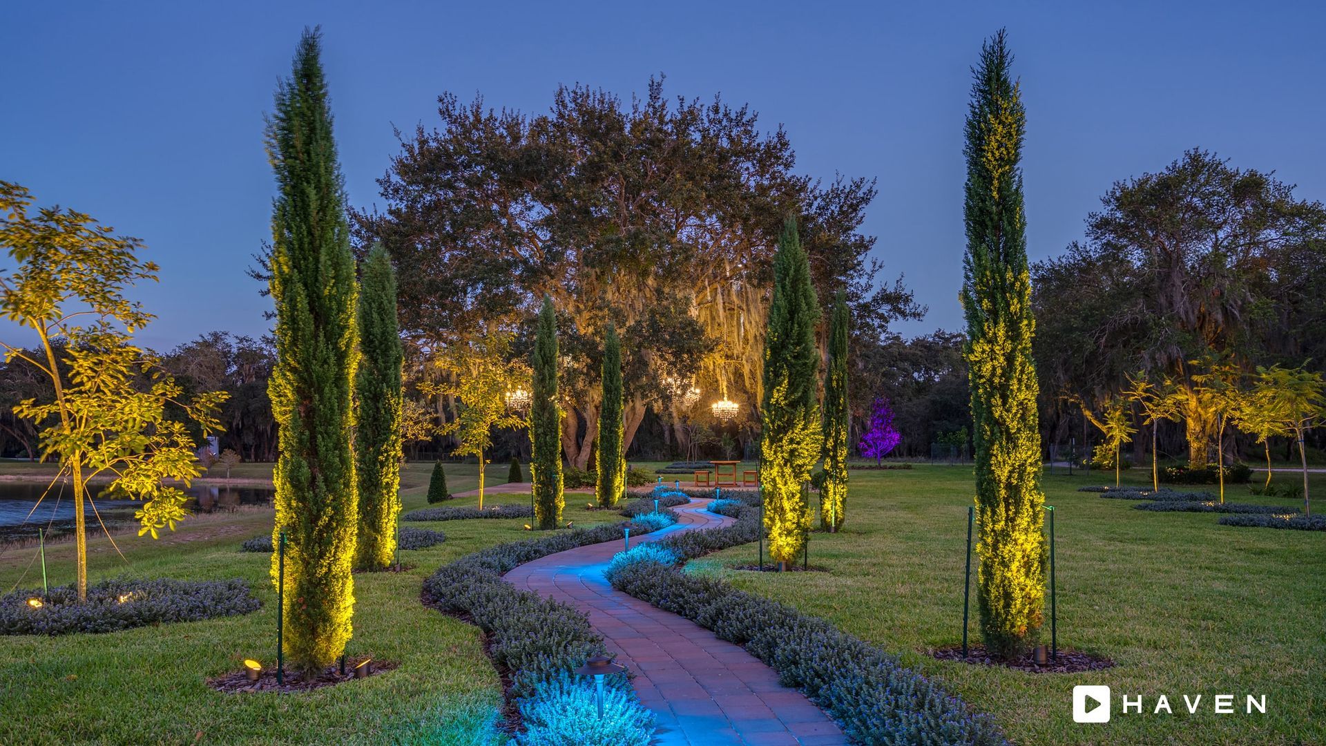 A path in a park with trees and a stream.