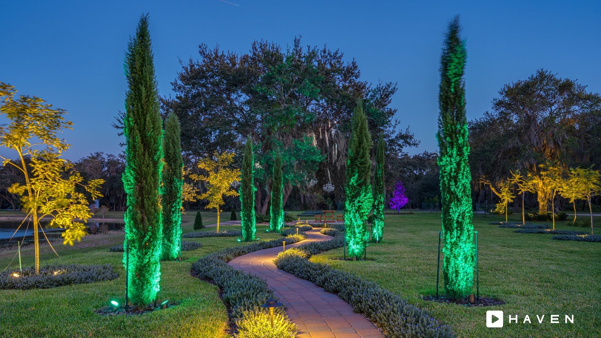 A path in a park with green lights on the trees