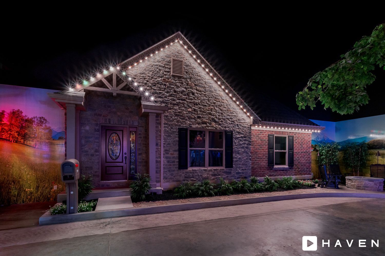 A house with christmas lights on it is lit up at night.