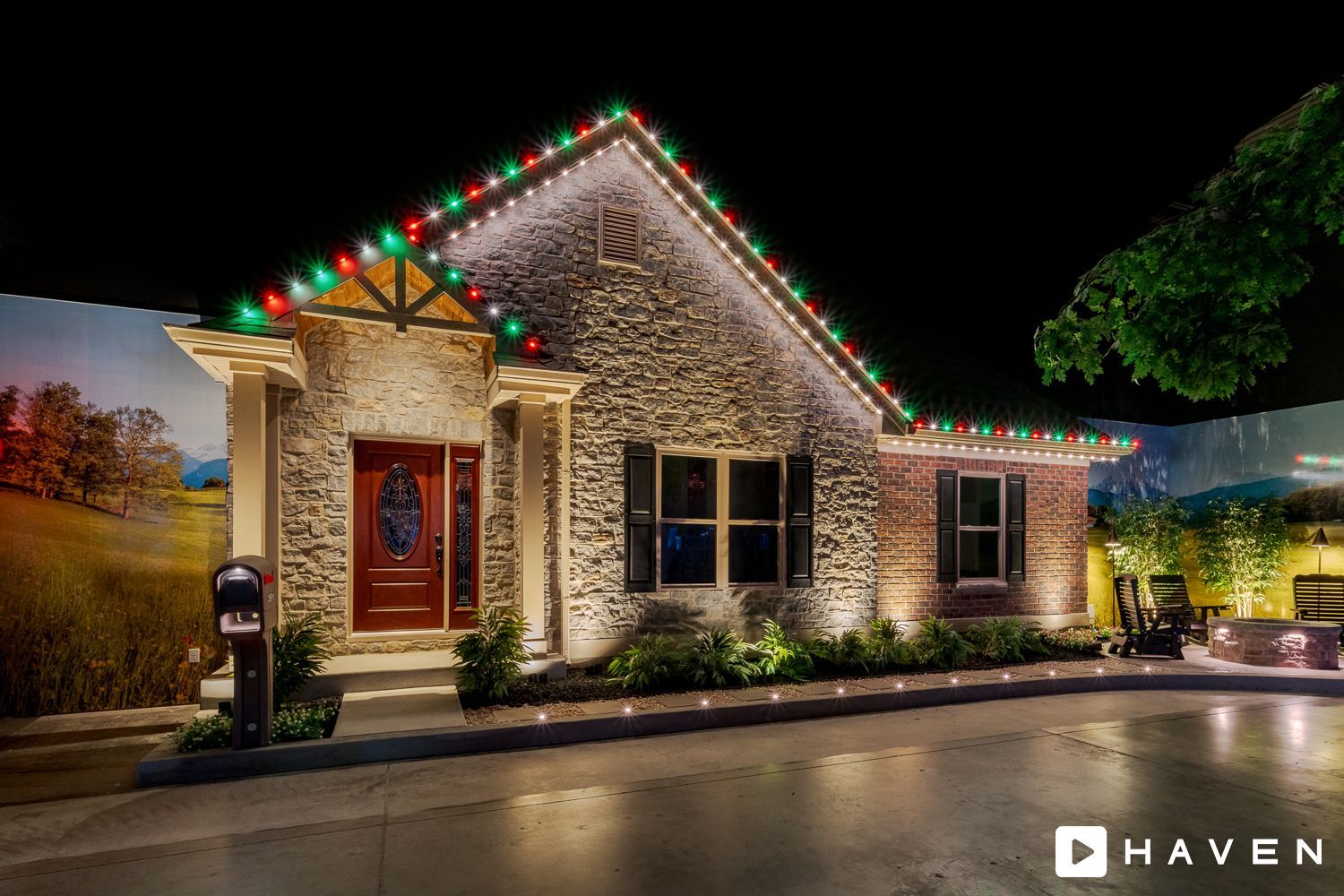 A house with christmas lights on the roof is lit up at night.