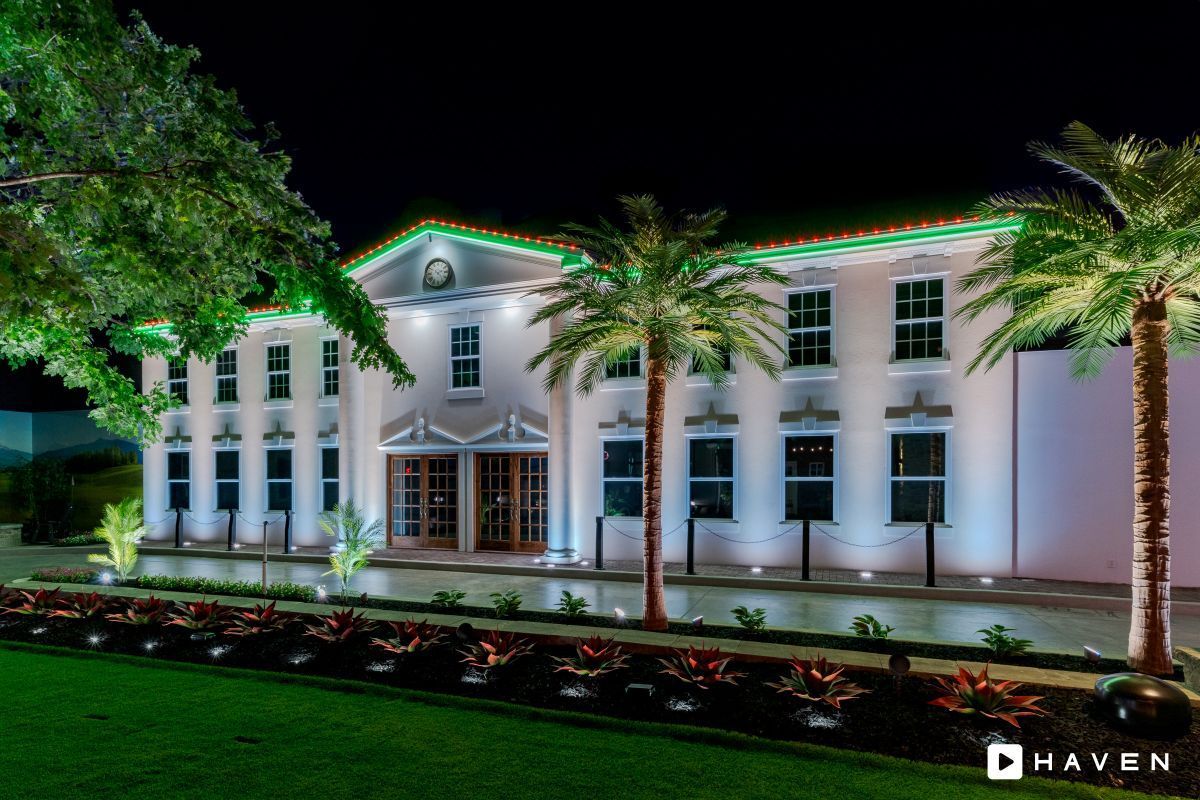 A large white building with palm trees in front of it