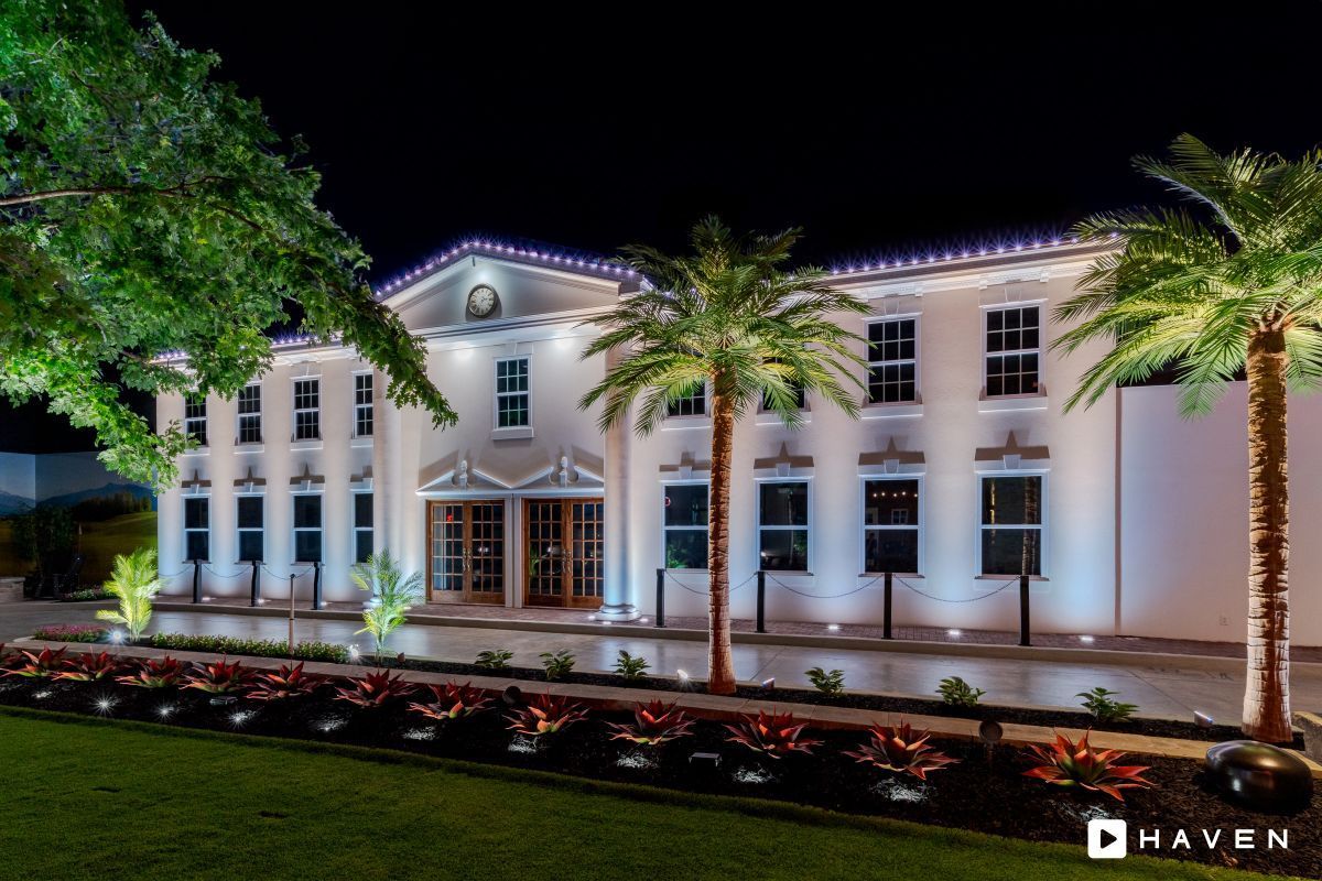 A large white building with palm trees in front of it