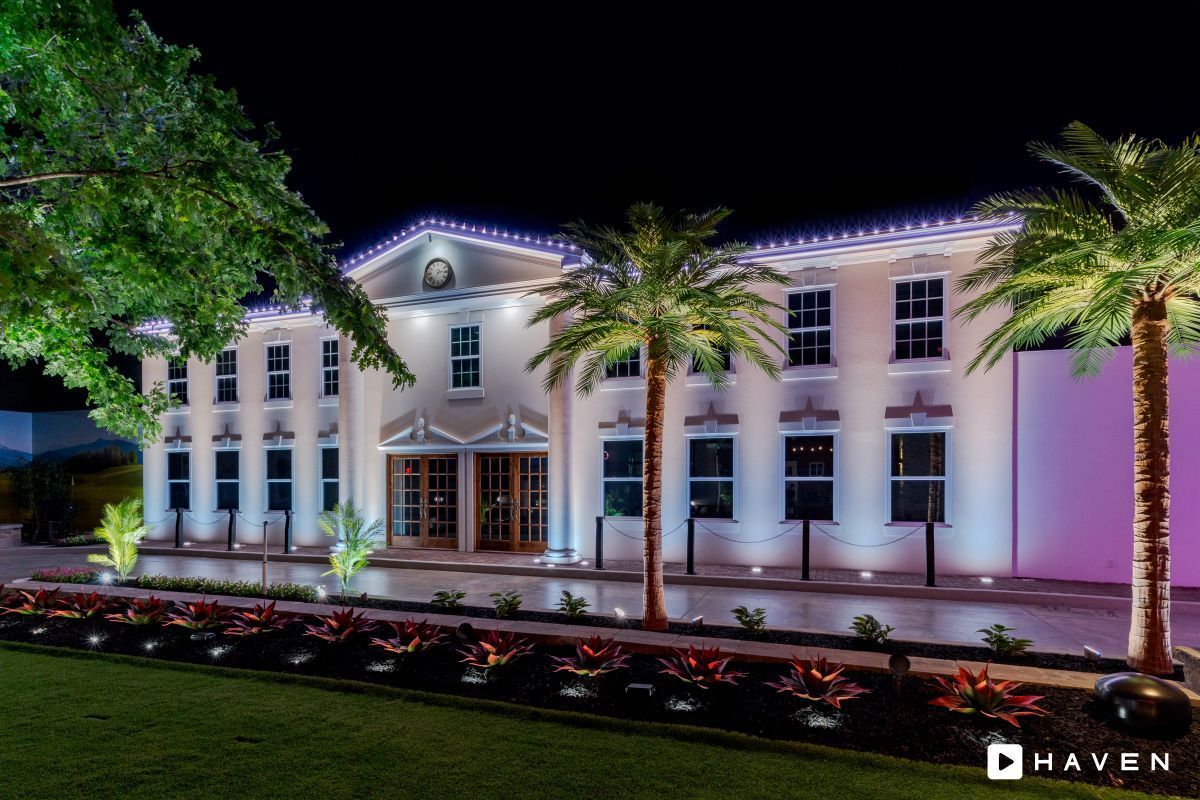 A large white building with palm trees in front of it