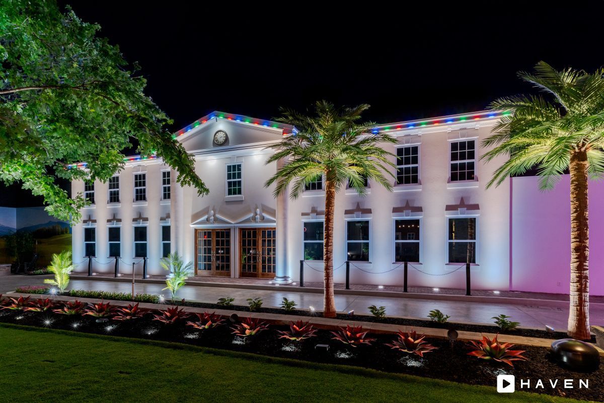 A large white building with palm trees in front of it