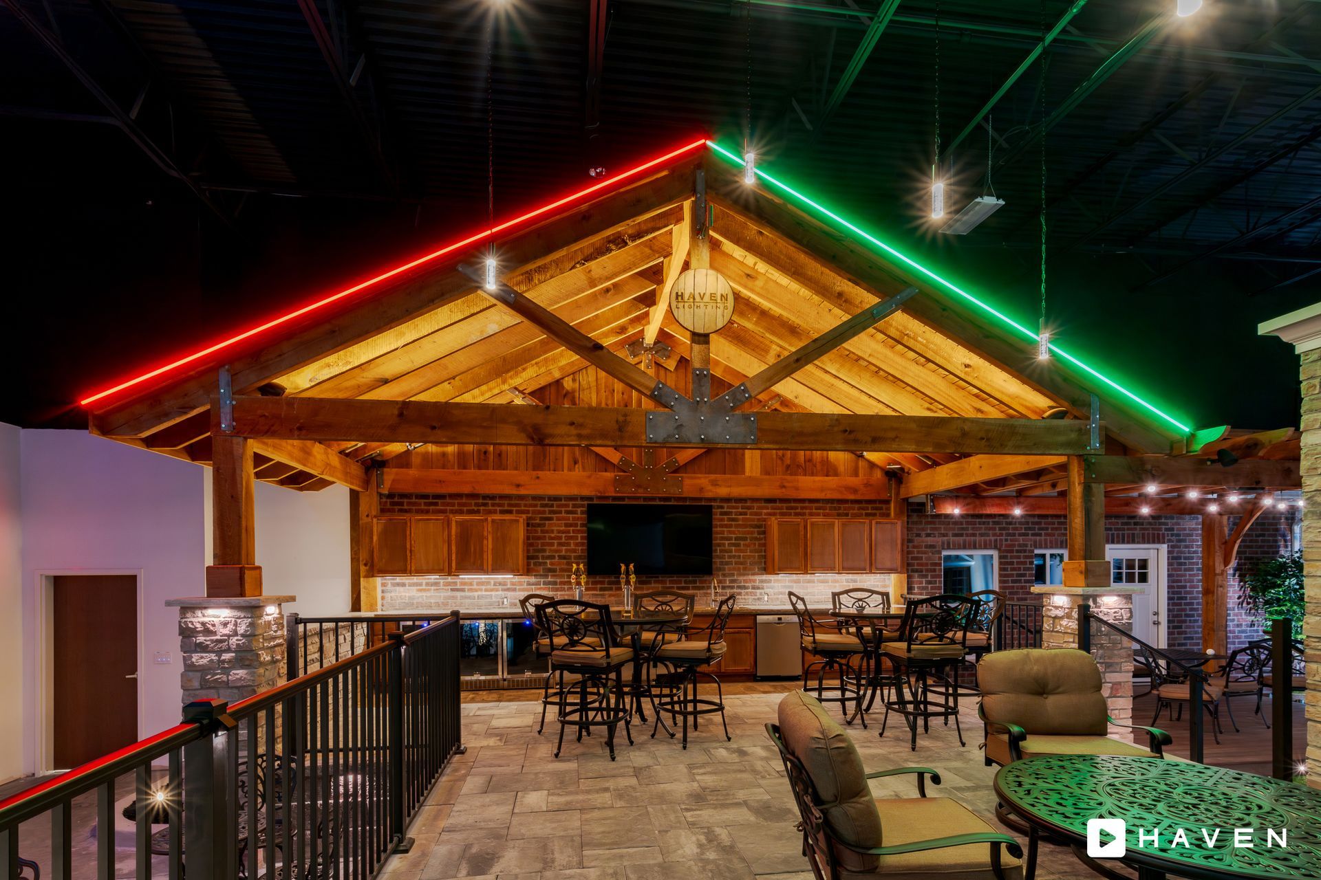 A large room with tables and chairs under a wooden roof.
