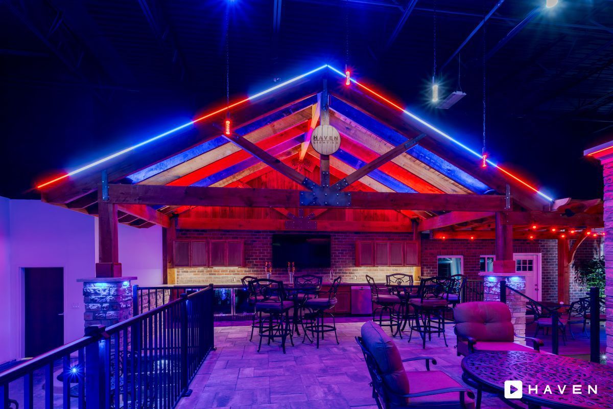 A large room with a lot of lights on the ceiling and tables and chairs.