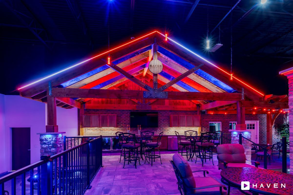A large room with tables and chairs and a colorful ceiling.