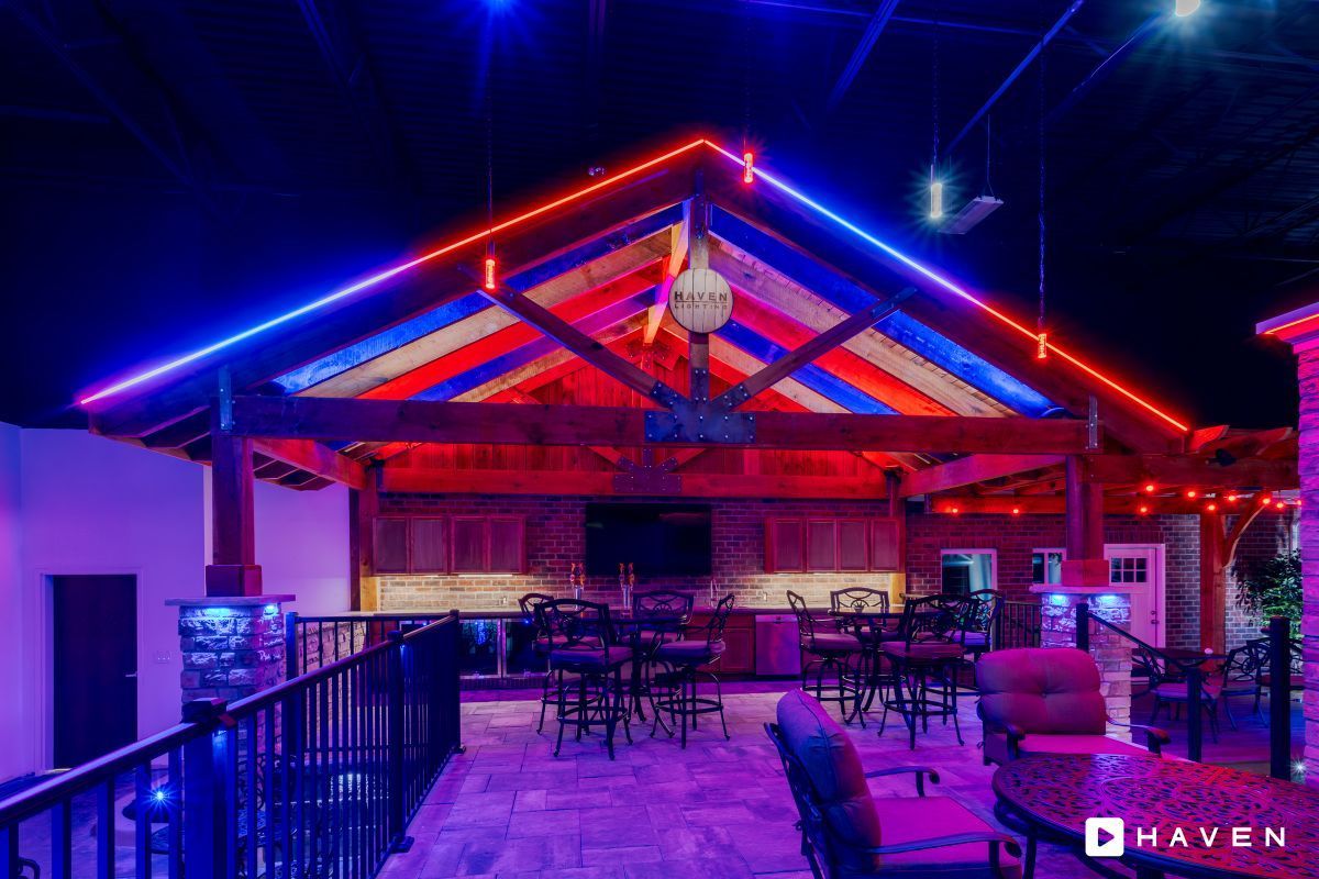 A large room with a lot of lights on the ceiling and tables and chairs.