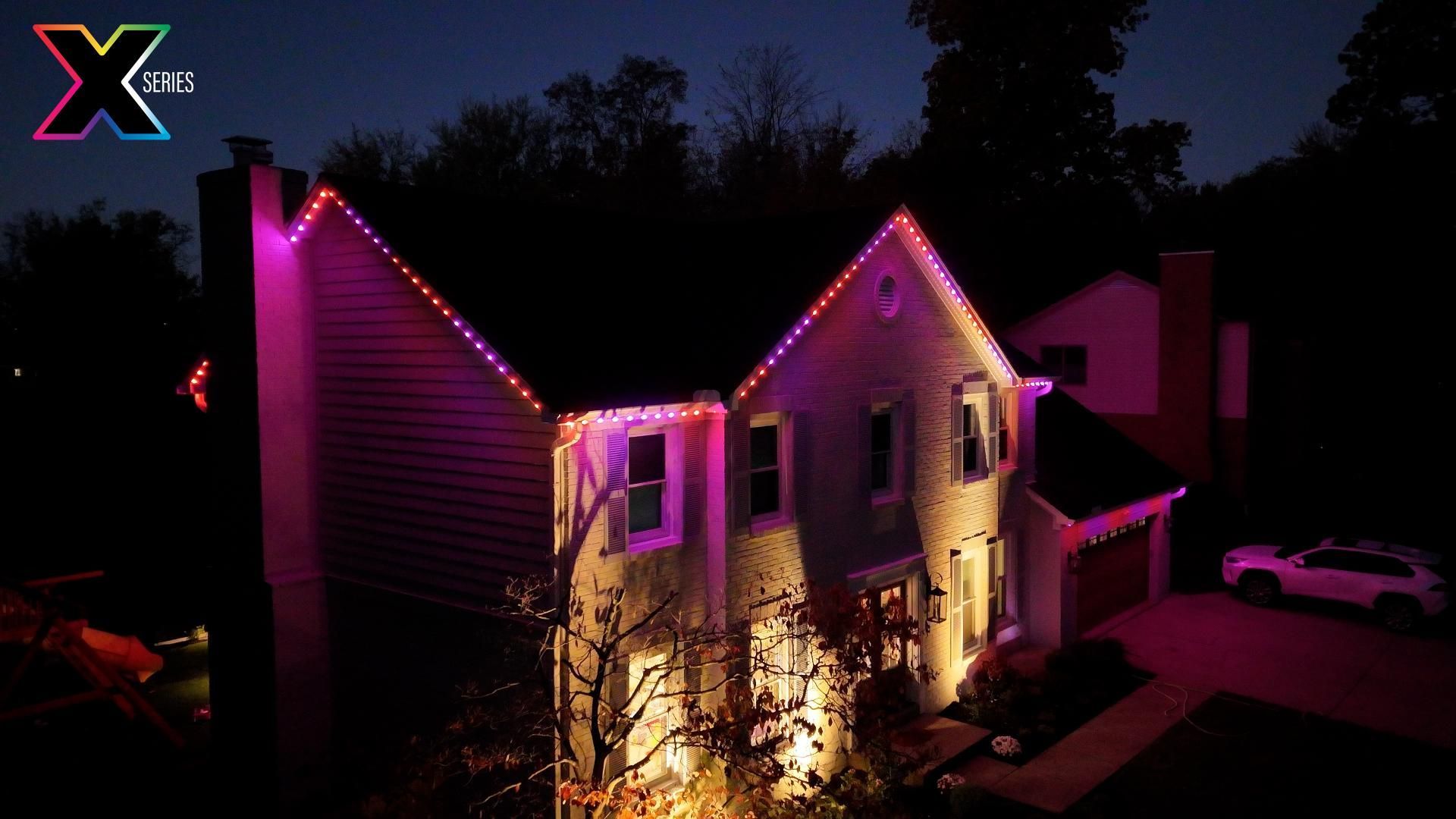 An aerial view of a house with purple lights on it