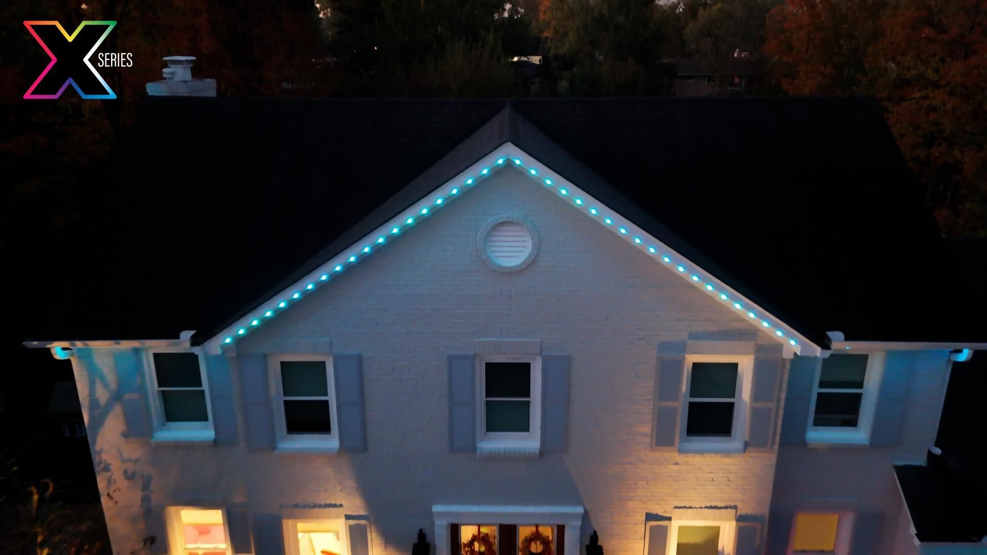 An aerial view of a house with christmas lights on it.