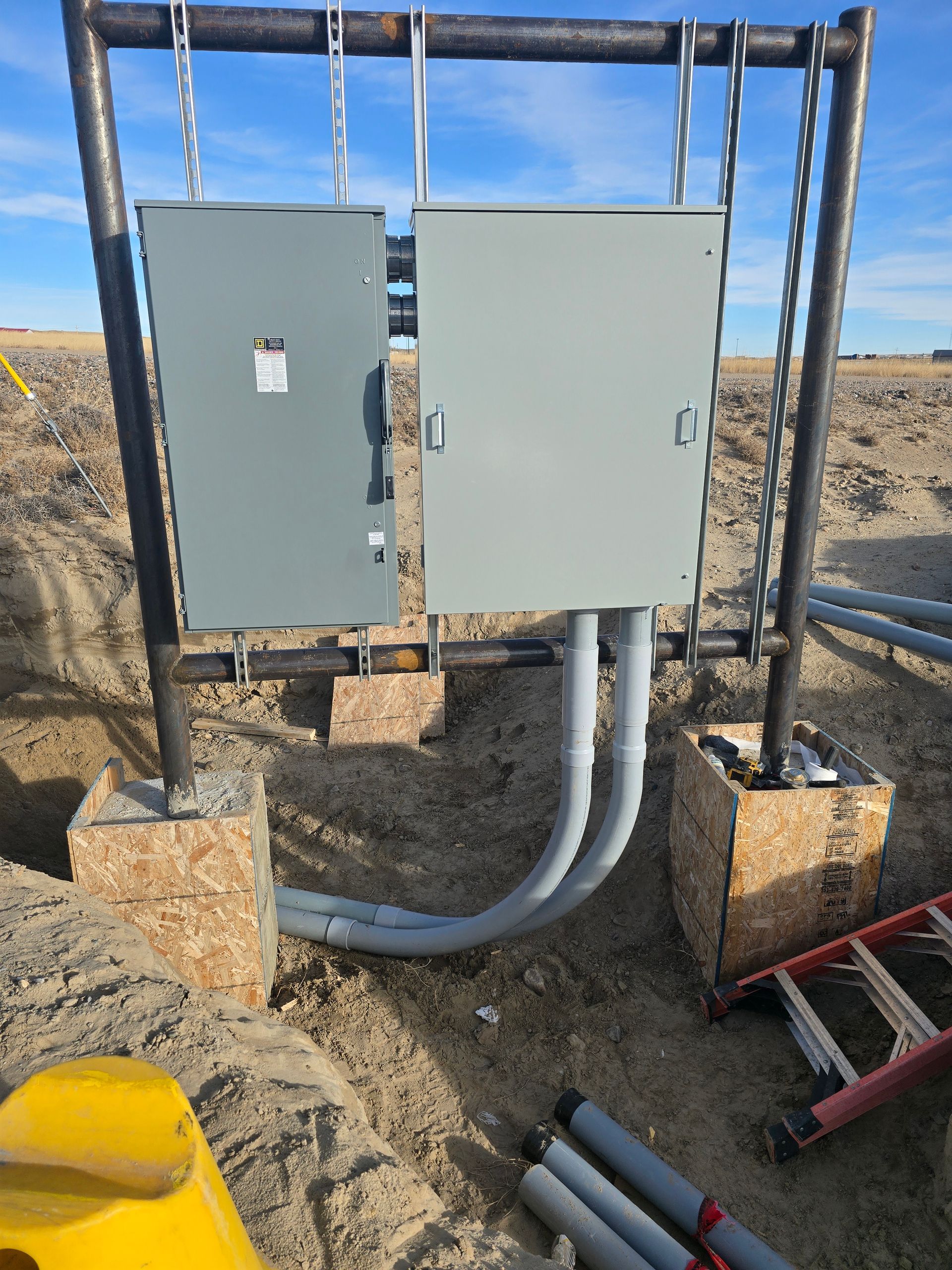 A ladder is sitting next to a box in the dirt.