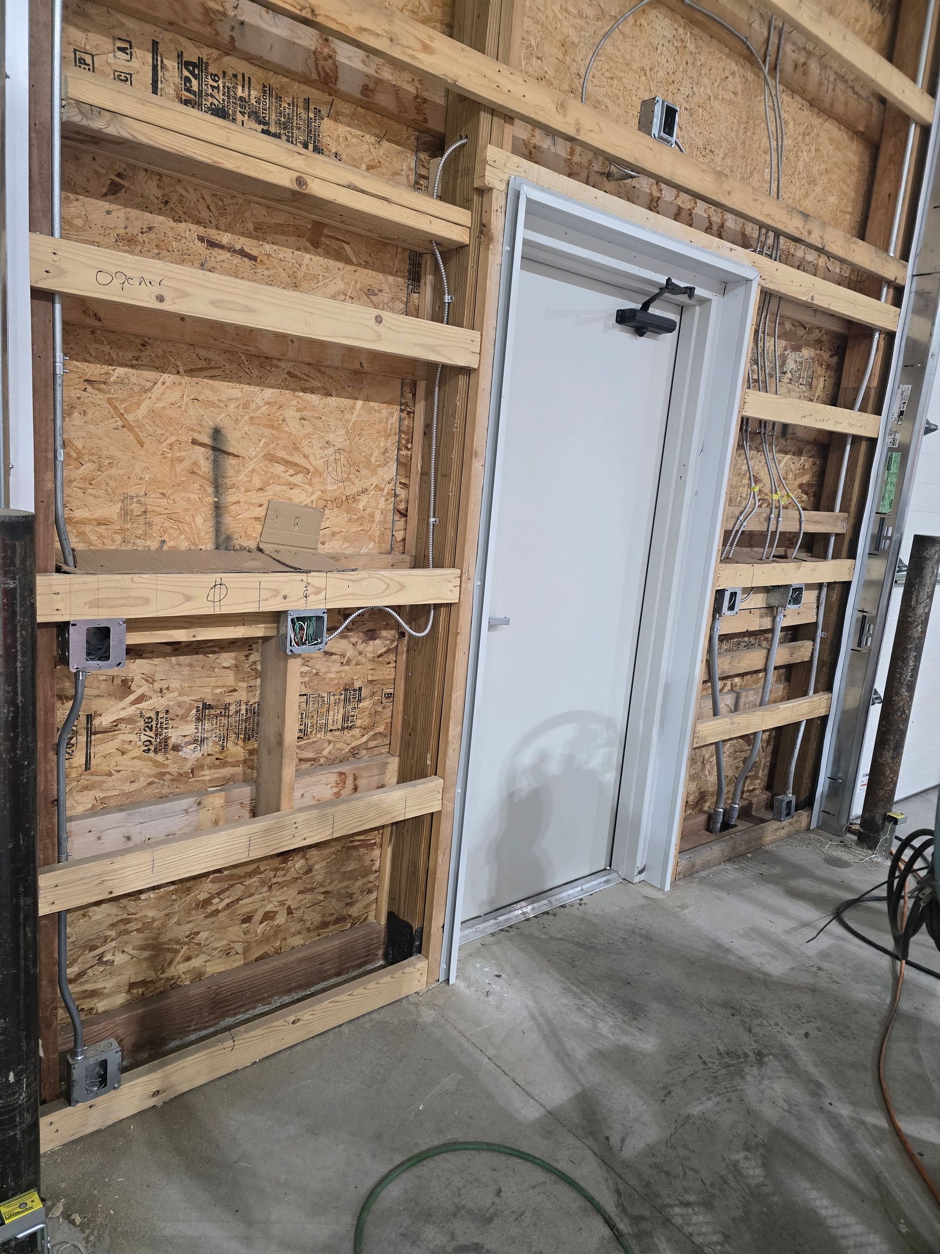 A white door is being built into a wooden wall.