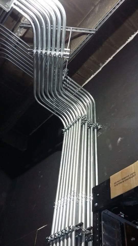A bunch of metal pipes are hanging from the ceiling of a building.
