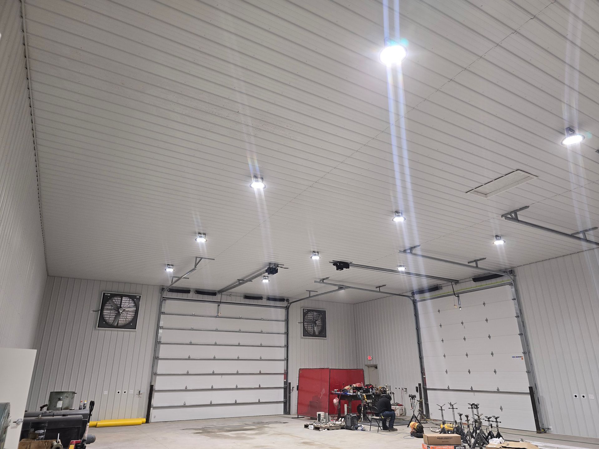 A large garage with a lot of doors and lights on the ceiling.