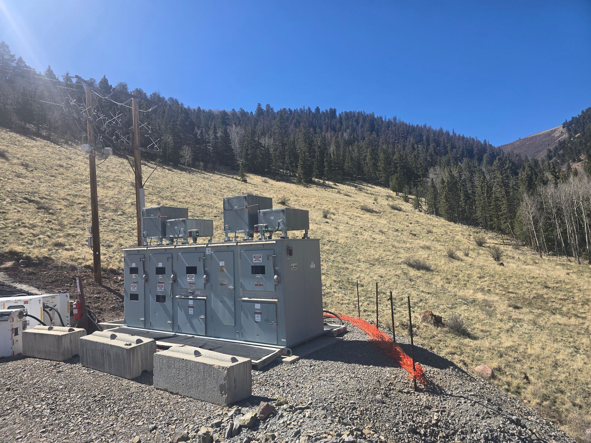 A large electrical box is sitting on top of a rocky hillside.