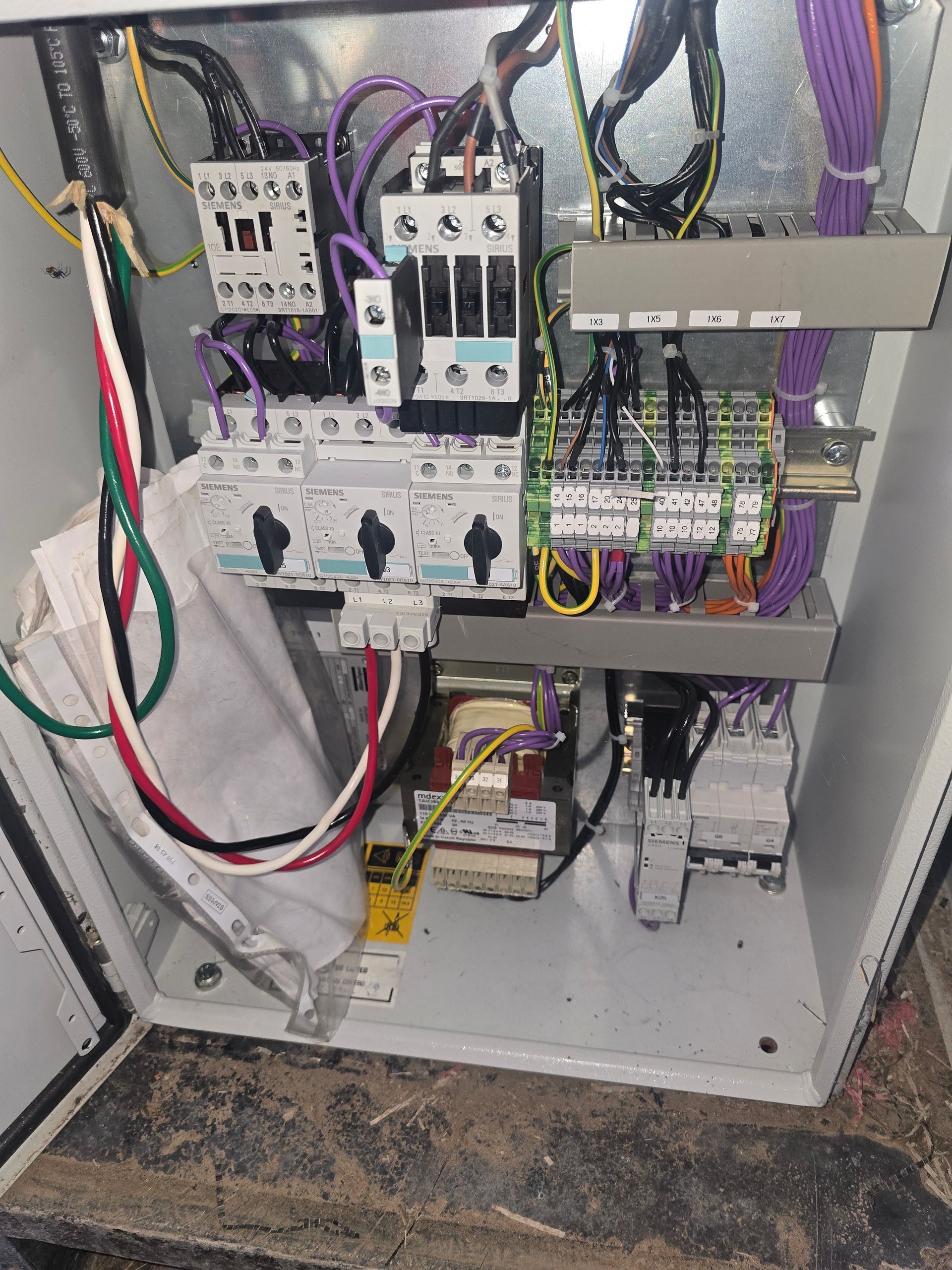 A close up of a electrical box with a lot of wires coming out of it.