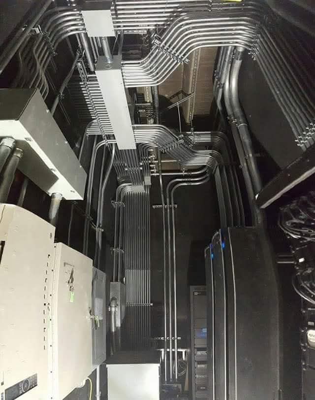 A bunch of pipes are hanging from the ceiling of a building