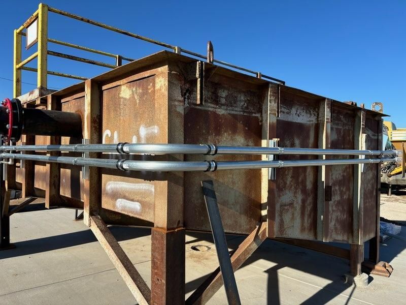 A large rusty metal structure with pipes attached to it