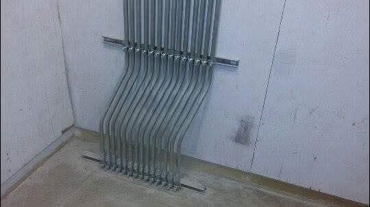 A bunch of metal pipes are hanging on a wall.