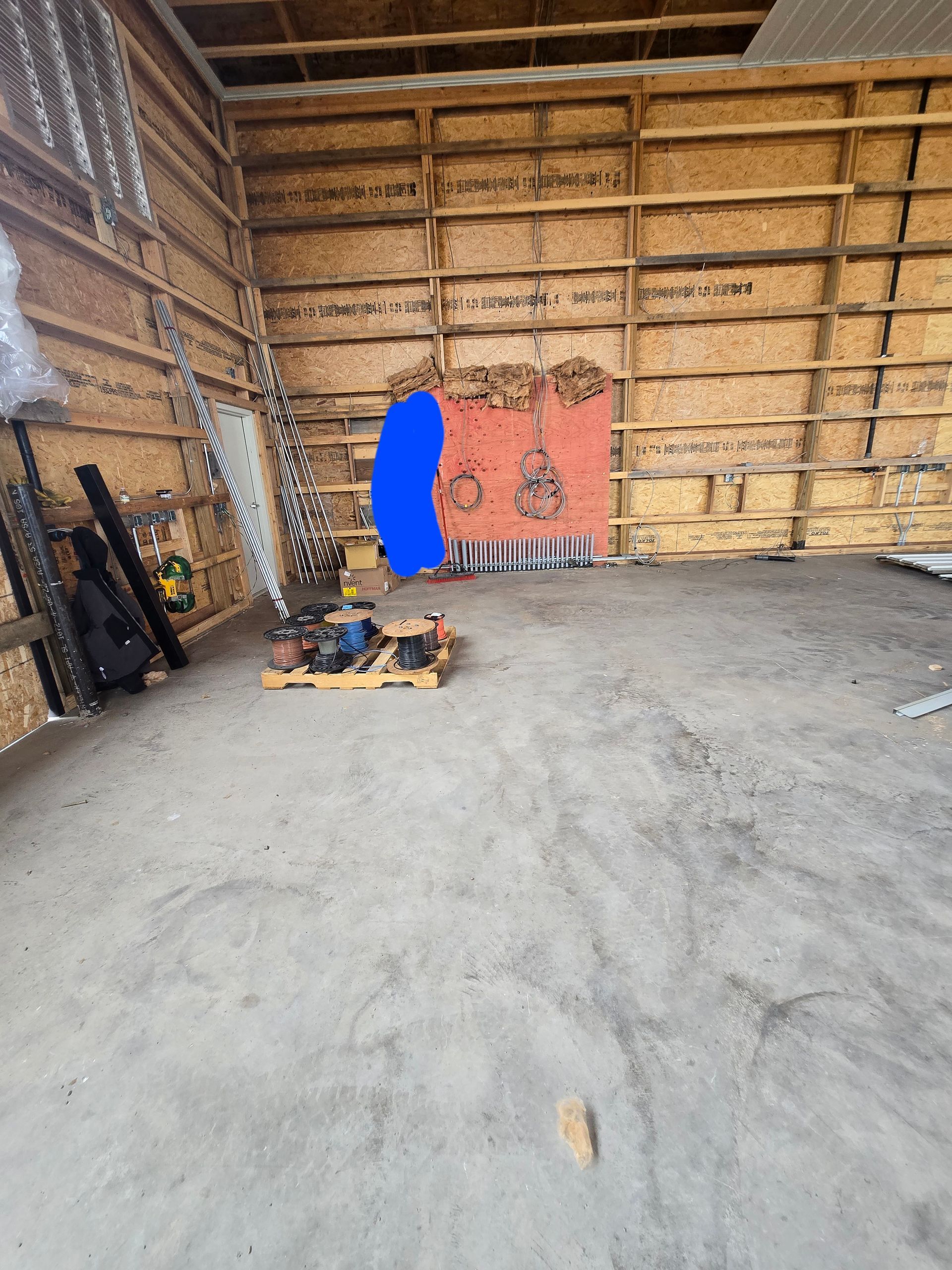 A room with a lot of wooden walls and a concrete floor.