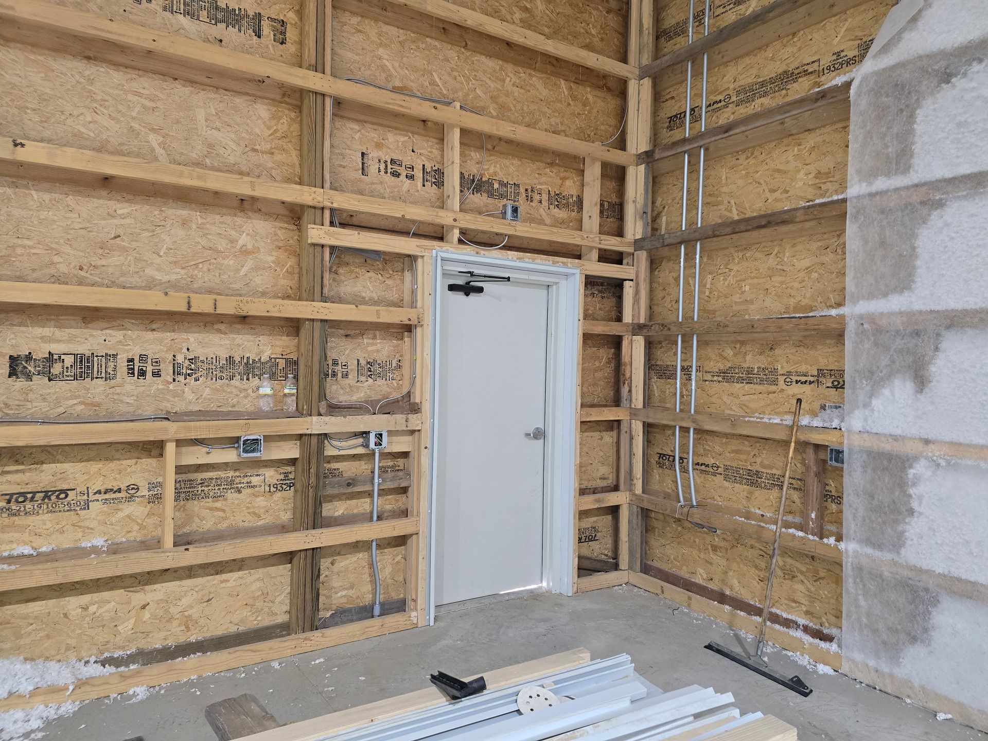 A room with wooden walls and a white door.