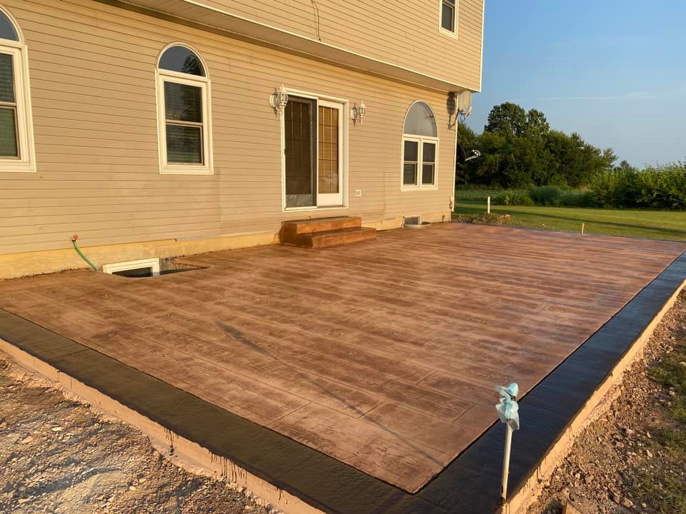 A large concrete patio is being built in front of a house.